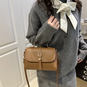 Dark brown lychee pattern leather handbag with gold buckle shown on a female model