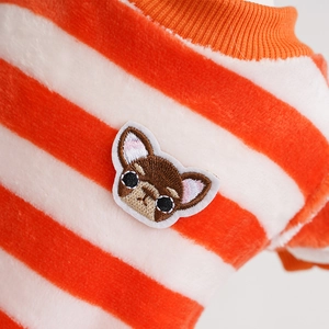 Close-up of fluffy orange striped pet sweater with a detailed bulldog embroidery patch