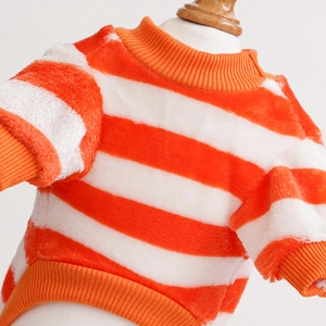 Close-up of orange and white striped winter pet sweater with warm plush fabric texture