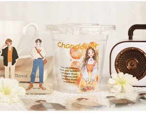 Close-up of vintage fashion figure stickers on a clear cup for journaling scrapbooks