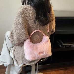 Pink plush faux fur tote bag with top handle and shoulder strap in lifestyle setting