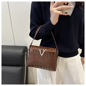 Mirror selfie showing a dark brown crocodile embossed handbag with a silver V-shaped logo