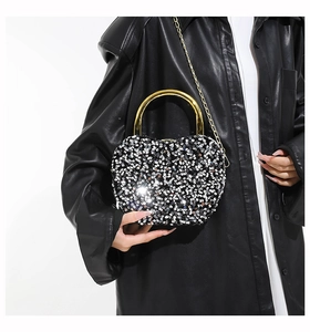 Detail of sequin-covered heart evening bag with gold ring handle and chain strap