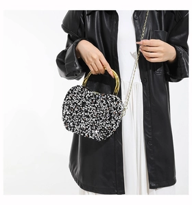 Detail of sequin evening bag with gold U-shaped handle and metal chain strap