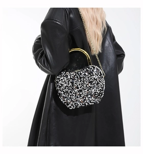 Detailed view of black and silver sequin evening bag with gold chain and handle