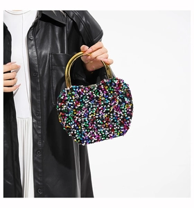Detailed shot of multi-color sequin handbag with large gold-tone circular metal handle