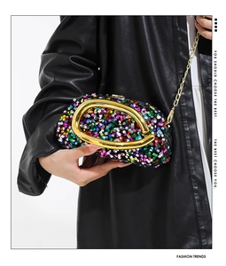 Detail of colorful sequined clutch bag with gold round metal handle and chain strap