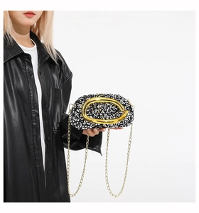 Detailed close-up of sequined evening clutch with large metallic gold ring ornament