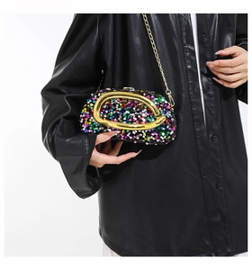 Detailed shot of vibrant multicolored sequin evening clutch with golden metal handle