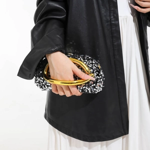 Sparkly black sequin evening clutch bag with an elegant curved gold metal handle for women
