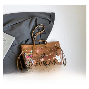 Flat lay of brown tote bag with graffiti cartoon prints and adjustable side drawstrings