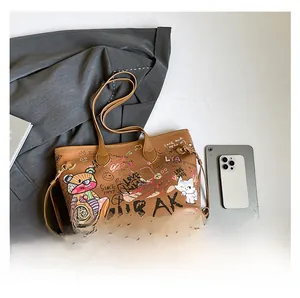 Close-up of brown PU leather tote bag featuring colorful bear graffiti and street art patterns