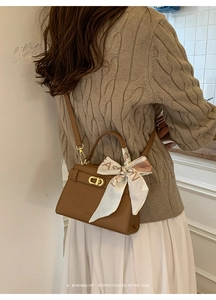 Détail d'un sac bandoulière en cuir marron avec boucle dorée et foulard en soie