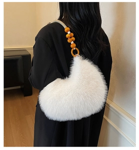 Detail of white faux fur handbag featuring bright orange beaded handle and gold rings