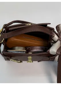 Vue détaillée du sac à main en cuir marron avec boucle dorée et capacité intérieure