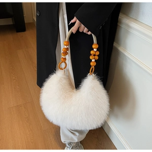 Detail of white faux fur handbag featuring wooden bead handle and plush texture