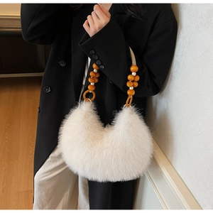 Detail of white faux fur handbag with vibrant orange beaded handle and half-moon silhouette