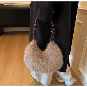 Close-up of faux fur shoulder bag with vintage beaded handle and soft plush texture