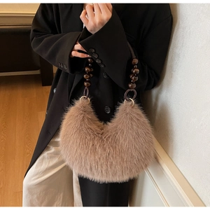 Detail of light brown plush handbag with vintage wooden bead handle and metal ring