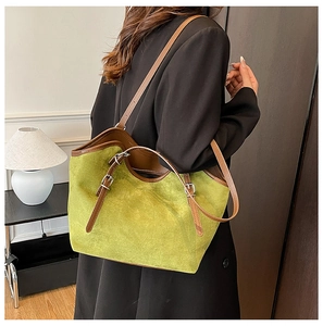 Back view of a large green suede tote bag with brown leather straps for commuting