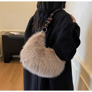 Detailed texture of brown faux fur hobo bag with artistic dark wooden beaded strap