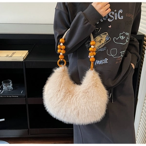 Detail of plush crescent handbag with vintage wooden bead handle and shaggy faux fur texture