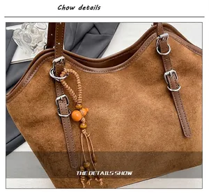 Close-up of vintage brown suede tote bag with stylish gourd bead charm detail