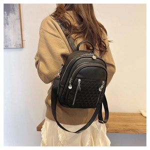 Dettaglio di uno zaino in pelle nera trapuntata su modella che mostra taglia e texture