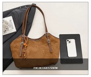 Brown frosted leather tote bag detail with tassel and phone for size comparison