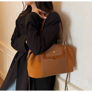 Detailansicht der karamellfarbenen Wildleder-Tragetasche mit Ledertasche und Metallverschluss