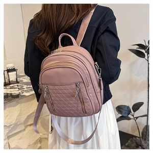 Dettaglio dello zaino in pelle rosa trapuntata con cerniere multiple e rifiniture