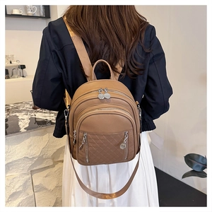 Dettaglio del mini zaino color cammello con motivo trapuntato e zip metalliche alla moda