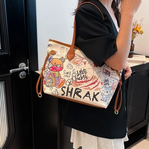 White graffiti tote bag with colorful cartoon patterns and brown trim shown on a model