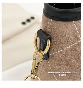 Detail of detachable gold-tone buckle and quilted khaki suede on a stylish bucket bag