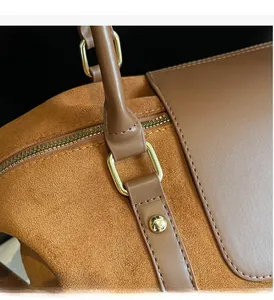 Détails du daim marron foncé et du cuir lisse avec des ferrures en métal doré brillant