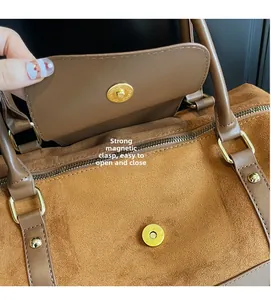 Détail du cabas en daim marron avec boucle magnétique puissante et garniture dorée