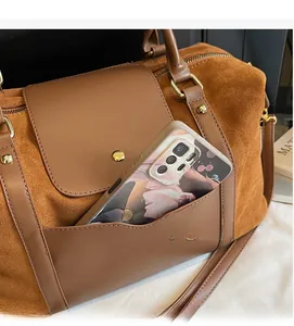 Détail de la poche avant du sac en daim camel montrant le rangement pour smartphone