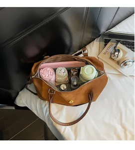 Vue de dessus d'un grand sac fourre-tout en daim marron rempli d'articles du quotidien