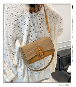 Detail of minimalist leather crossbody bag with woven texture on model back profile