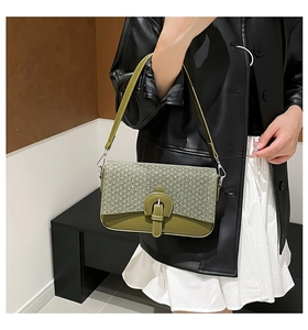 Detail of army green quilted crossbody bag with textured fabric and leather strap
