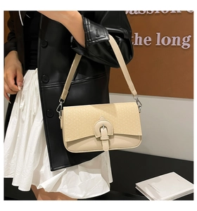 Détail du sac beige avec rabat tissé et boucle en métal en forme de fer à cheval