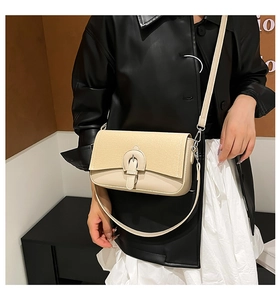 Detail of beige crossbody bag featuring textured woven flap and premium leather finish