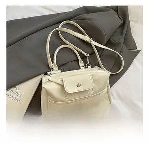 Detail of cream white faux leather tote with magnetic front pocket and adjustable strap