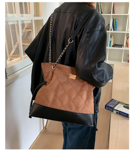 Vue détaillée d'un grand sac cabas en daim matelassé marron avec bandoulière dorée