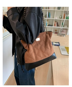 Détail du cabas en daim marron vintage avec matelassage et bandoulière chaîne sur modèle