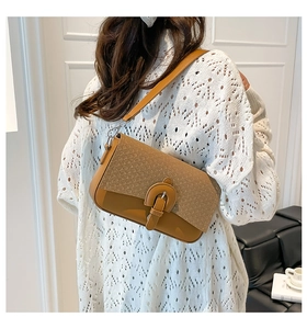 Back view of a woven texture crossbody bag on model in minimalist interior
