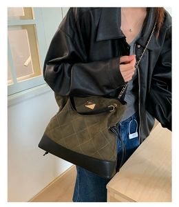 Détail du sac fourre-tout en daim vert olive avec texture matelassée et design mixte
