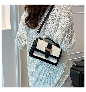 Detail of checkered embossed leather crossbody bag with gold buckle on a model
