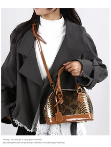 Detail of brown snakeskin shell bag featuring glossy patent leather straps and gold hardware