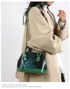 Detail of green snake pattern faux leather texture with glossy patent finish on shell bag